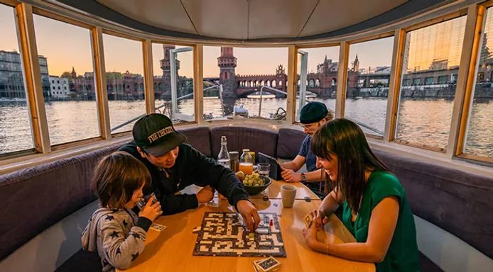 Family at the table with panoramic view of Berlin Oberbaumbrücke
